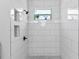 Bright shower with white subway tiles, a mosaic shower floor, black fixtures and a recessed shower shelf at 8003 Lake Nellie Rd, Clermont, FL 34714