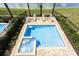 Backyard pool and spa with lush landscaping and a nearby lake at 834 Golden Bear Dr, Reunion, FL 34747
