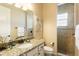 Bathroom with granite countertop, stylish mirror, and glass-enclosed shower, creating a spa-like experience at 834 Golden Bear Dr, Reunion, FL 34747