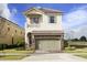 Charming two-story home with a stone-accented garage and a cozy second-floor balcony at 834 Golden Bear Dr, Reunion, FL 34747