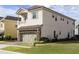 Two-story home featuring multiple vertical windows and a stone-accented garage at 834 Golden Bear Dr, Reunion, FL 34747
