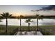 Scenic lake view from the patio, complete with palm trees and comfortable seating, ideal for relaxation at 834 Golden Bear Dr, Reunion, FL 34747