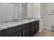 Bathroom with granite countertop, dark wood cabinets, and a white door leading to the shower and toilet at 838 Kildrummy Dr, Davenport, FL 33896