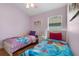 bedroom features two twin beds with colorful bedding, ceiling fan and window at 838 Kildrummy Dr, Davenport, FL 33896