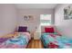bedroom features two twin beds with colorful bedding and wooden floor at 838 Kildrummy Dr, Davenport, FL 33896