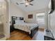 Bedroom featuring a ceiling fan, tv, wood floors, bedside tables, and a large decorative bed spread at 838 Kildrummy Dr, Davenport, FL 33896
