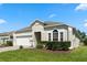 Charming single-story home featuring a well-manicured lawn, brick driveway, and a two-car garage at 838 Kildrummy Dr, Davenport, FL 33896