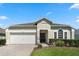 Charming single-story home featuring a well-manicured lawn, brick driveway, and a two-car garage at 838 Kildrummy Dr, Davenport, FL 33896