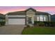 Charming single-story home featuring a well-manicured lawn, brick driveway, and a two-car garage at 838 Kildrummy Dr, Davenport, FL 33896