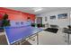 Finished garage featuring a ping pong table, foosball, black carpet, bar stools, and painted walls at 838 Kildrummy Dr, Davenport, FL 33896