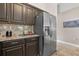 Close up of kitchen with stainless steel refrigerator and dark wood cabinets at 838 Kildrummy Dr, Davenport, FL 33896