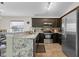 Kitchen with stainless steel appliances, dark cabinetry, and granite countertops at 838 Kildrummy Dr, Davenport, FL 33896