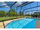 Enclosed pool and hot tub area with privacy fence and green backyard at 838 Kildrummy Dr, Davenport, FL 33896