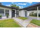 Quaint home exterior with dark trim and convenient carport in a lush, green setting at 843 W Swoope Ave, Winter Park, FL 32789
