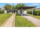 Inviting home exterior featuring a manicured lawn and a covered carport with a paved driveway at 843 W Swoope Ave, Winter Park, FL 32789