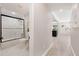 Hallway view leading to a bathroom and the front door in a neutral color palette at 843 W Swoope Ave, Winter Park, FL 32789