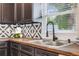 Close up of the kitchen sink with modern faucet, wood countertops, and geometric backsplash at 843 W Swoope Ave, Winter Park, FL 32789