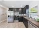 Stylish kitchen boasts stainless steel appliances, black cabinets, and a unique geometric tile backsplash at 843 W Swoope Ave, Winter Park, FL 32789