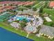 Aerial view of the community pool and clubhouse surrounded by lush landscaping and colorful townhomes at 8971 California Palm Rd, Kissimmee, FL 34747