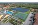 Aerial view of community pool, lake, and sports courts showcases the variety of outdoor amenities at 8971 California Palm Rd, Kissimmee, FL 34747