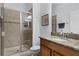 Bathroom features a glass door shower and granite countertop vanity with a framed mirror at 8971 California Palm Rd, Kissimmee, FL 34747