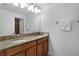 Bathroom featuring a double sink vanity with granite countertops and ample mirror space at 8971 California Palm Rd, Kissimmee, FL 34747