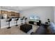 Bright living room with bar seating at kitchen counter, tile floors, and modern entertainment center at 8971 California Palm Rd, Kissimmee, FL 34747