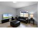 Living room featuring a black leather sofa, ottoman, TV, and tile floors at 8971 California Palm Rd, Kissimmee, FL 34747