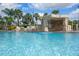 Beautiful community pool featuring a rock grotto, waterfall, and lush landscaping at 8971 California Palm Rd, Kissimmee, FL 34747
