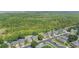 From above, a tranquil neighborhood sits near a lush green forest, offering quiet suburban living at 9999 Shadow Creek Dr, Orlando, FL 32832