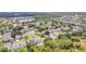 Aerial view of a well-maintained neighborhood with mature trees, landscaping, and a tranquil lake at 9999 Shadow Creek Dr, Orlando, FL 32832