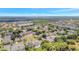 A beautiful aerial shot displays a suburban neighborhood nestled among green trees and a serene lake at 9999 Shadow Creek Dr, Orlando, FL 32832