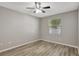 This bedroom features wood-look floors, a ceiling fan, neutral paint and a window at 9999 Shadow Creek Dr, Orlando, FL 32832
