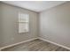 Neutral bedroom featuring wood-look flooring and a window at 9999 Shadow Creek Dr, Orlando, FL 32832