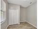 This bedroom has wood-look floors, a closet and neutral paint at 9999 Shadow Creek Dr, Orlando, FL 32832