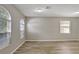 Spacious room featuring three windows and wood-look flooring at 9999 Shadow Creek Dr, Orlando, FL 32832