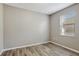 Bright, neutral bedroom featuring a window and wood-look flooring at 9999 Shadow Creek Dr, Orlando, FL 32832