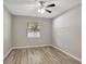 This bedroom features wood-look floors, a ceiling fan, neutral paint and a window at 9999 Shadow Creek Dr, Orlando, FL 32832