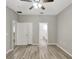 This bedroom features wood-look floors, ceiling fan, neutral paint, and an attached bathroom at 9999 Shadow Creek Dr, Orlando, FL 32832