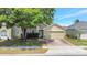 Charming home featuring a well-manicured lawn, brick driveway, attached two-car garage, and mature tree at 9999 Shadow Creek Dr, Orlando, FL 32832