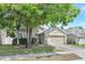 A two-story home is landscaped with healthy green foliage and mature trees at 9999 Shadow Creek Dr, Orlando, FL 32832