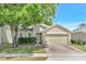A two-story home is landscaped with healthy green foliage and mature trees at 9999 Shadow Creek Dr, Orlando, FL 32832