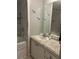 Bright bathroom with granite vanity, decorative starfish, and tiled shower at 117 Darlene Ct, Davenport, FL 33897