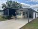 Well-maintained exterior with a carport, landscaped yard, and a charming screened-in porch at 117 Darlene Ct, Davenport, FL 33897