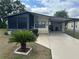 Charming single-story home with a well-maintained lawn, carport, and a screen room at 117 Darlene Ct, Davenport, FL 33897