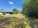 Large open backyard with a screened-in porch and a fire pit area at 12015 Se 72Nd Court Rd, Belleview, FL 34420