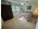 Carpeted bedroom with neutral tones, a ceiling fan, large window, and an armoire at 12015 Se 72Nd Court Rd, Belleview, FL 34420