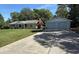 Wide concrete driveway leading to a cozy one-story home with a detached two car garage at 12015 Se 72Nd Court Rd, Belleview, FL 34420