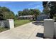Long driveway leading to a charming one-story home and detached two-car garage on a sunny day at 12015 Se 72Nd Court Rd, Belleview, FL 34420