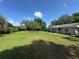 Large front yard showcasing the home's curb appeal, with mature trees and a well-maintained lawn at 12015 Se 72Nd Court Rd, Belleview, FL 34420